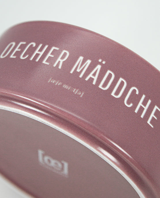 Detailaufnahme einer rosafarbenen Keramikschale mit weißem Aufdruck „Oecher Mäddche“.