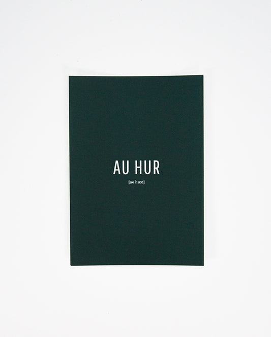 Dunkelgrüne Postkarte mit weißer Aufschrift „AU HUR“ in Großbuchstaben, darunter in kleiner Schrift die phonetische Schreibweise „[ao huːr]“.