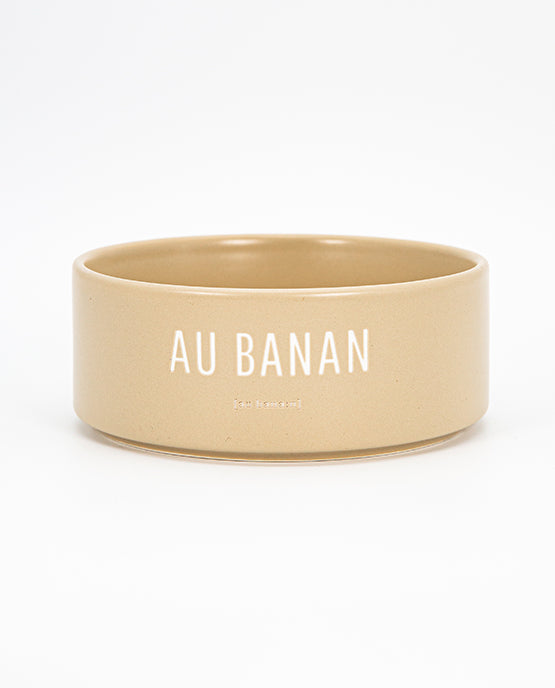 Beige Keramischale mit weißem Schriftzug „AU BANAN“ vor weißem Hintergrund 