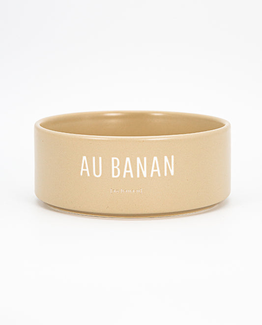 Beige Keramischale mit weißem Schriftzug „AU BANAN“ vor weißem Hintergrund 