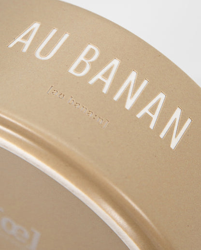 Detailaufnahme einer beige-gelben Keramikschale mit weißem Schriftzug „AU BANAN“. 