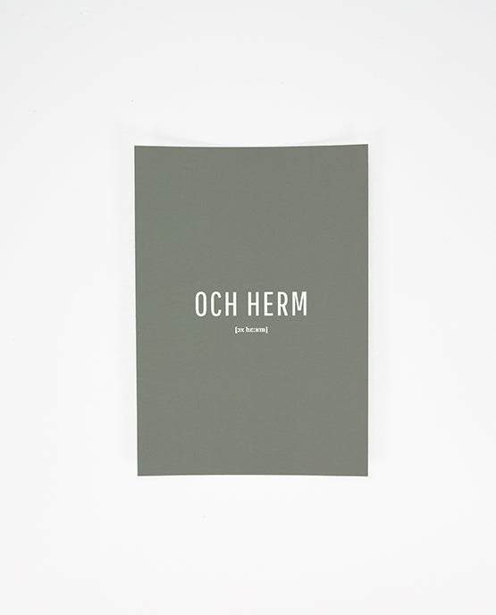 Vorderseite einer grauen Postkarte mit der weißen Aufschrift „OCH HERM“ in Großbuchstaben und der phonetischen Schreibweise „[ɔx hɛ:ʁm]“ darunter.