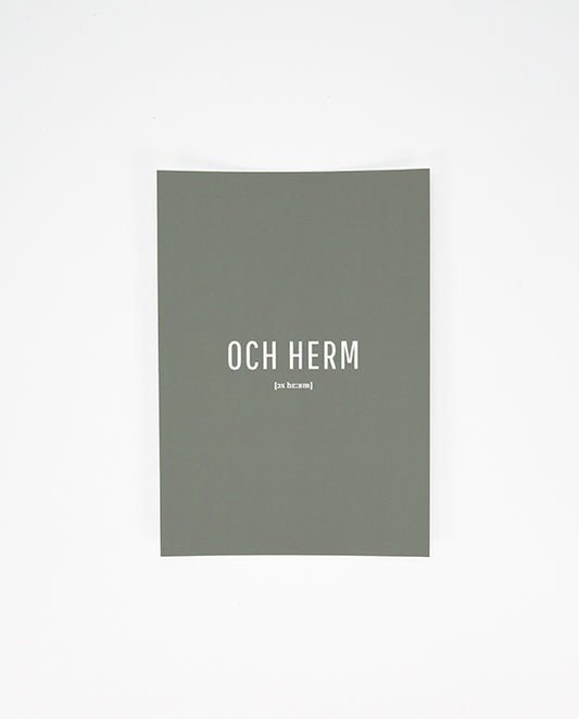 Vorderseite einer grauen Postkarte mit der weißen Aufschrift „OCH HERM“ in Großbuchstaben und der phonetischen Schreibweise „[ɔx hɛ:ʁm]“ darunter.