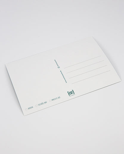 Rückseite einer weißen Postkarte mit Linienfeld für die Adresse, kleinem [oe]-Logo unten rechts in Türkis und Auswahlkästchen mit den Beschriftungen „ADIEDA“, „TSCHÖÖ, WA!“ und „MACH ET JOT“ unten links.