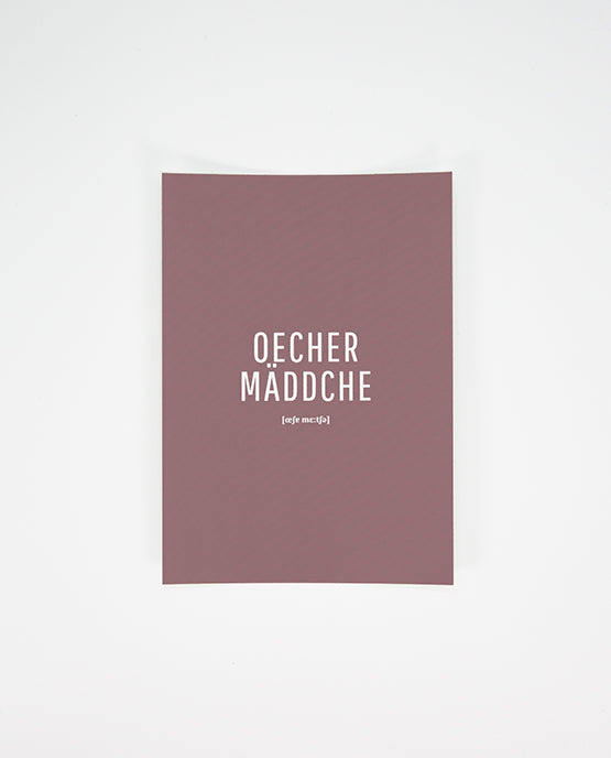 Postkarte in dunklem Altrosa mit dem weißen Aufdruck „Oecher Mäddche“ und der Lautschrift darunter, mittig platziert auf der Vorderseite.