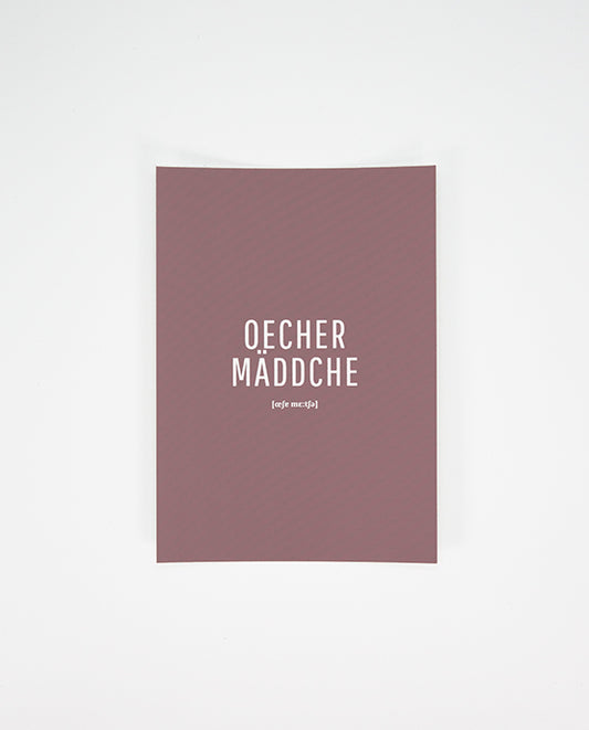 Postkarte in dunklem Altrosa mit dem weißen Aufdruck „Oecher Mäddche“ und der Lautschrift darunter, mittig platziert auf der Vorderseite.