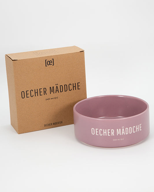 Rosafarbene Keramikschale mit weißem Aufdruck „OECHER MÄDDCHE“ neben einer braunen Kartonverpackung mit gleicher Beschriftung.