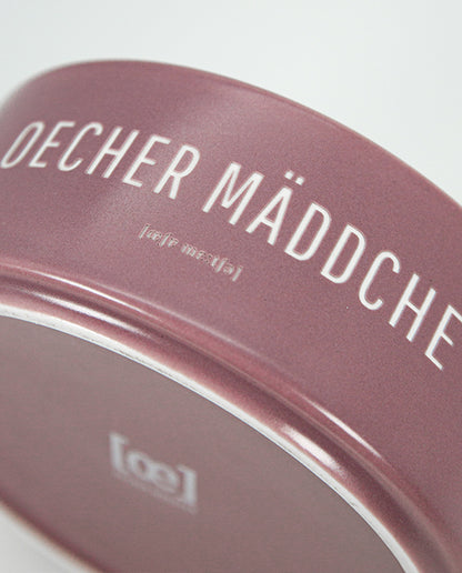 Detailaufnahme einer rosafarbenen Keramikschale mit weißem Aufdruck „Oecher Mäddche“.
