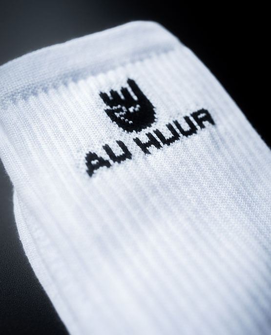 Weiße Socken mit schwarzem "AU HUUR"-Spruch und abstraktem Klenkes Symbol in Nahaufnahme