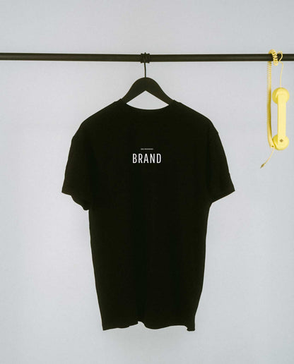 Schwarzes T-Shirt mit markantem, mittig platziertem Schriftzug „BRAND“ in klaren Großbuchstaben. Darüber steht dezent [NULLZWEIVIEREINS] – ein stilvolles Statement für alle, die ihren Aachener Stadtteil mit Selbstbewusstsein tragen wollen.